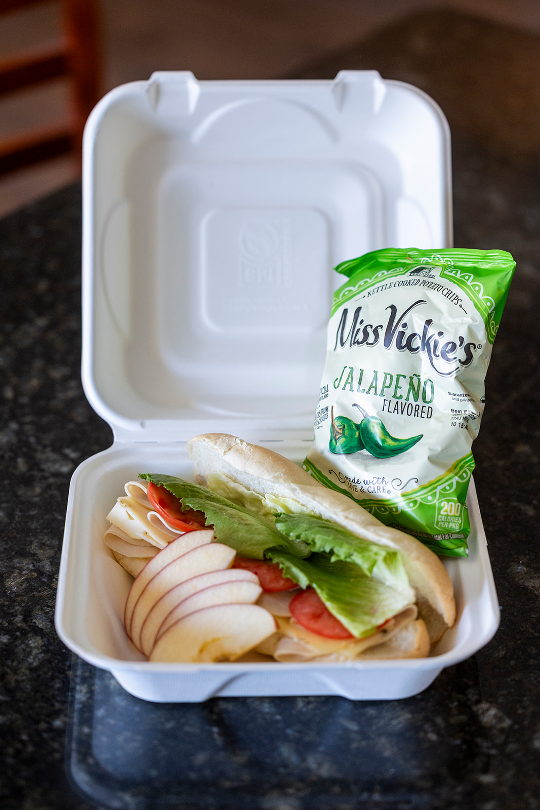 Boat lunch sandwich with sliced apples and chips