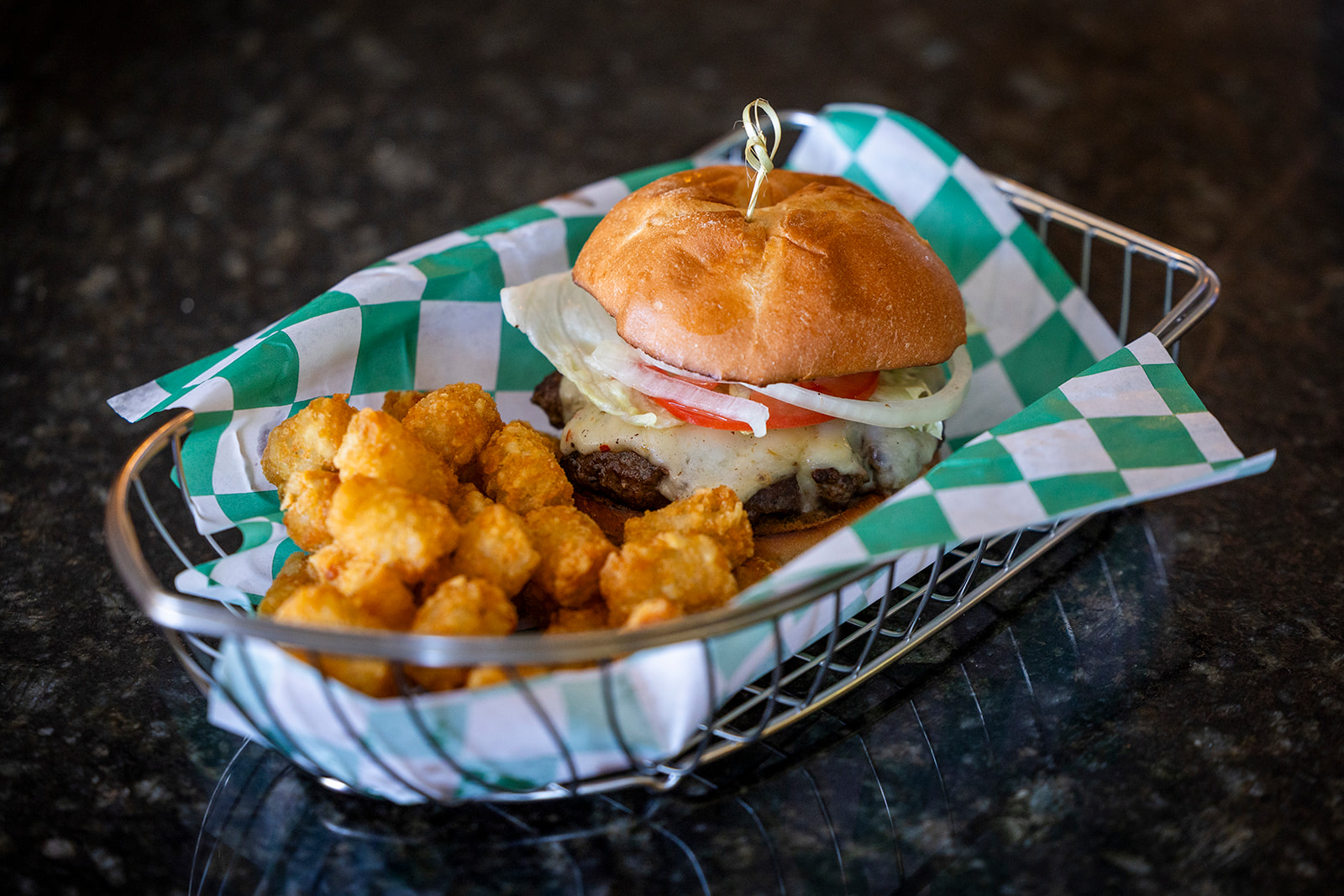 Burger with lettuce, tomato, and tater tots