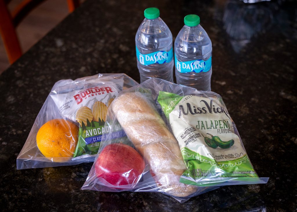 Packed boat lunches with sandwiches, fruit, chips, and bottled water